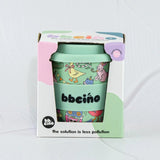 Green coffee cup with colorful design and 'bbecca' branding in a box on a white background