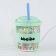 Mint green tumbler with colorful design and straw on a white background